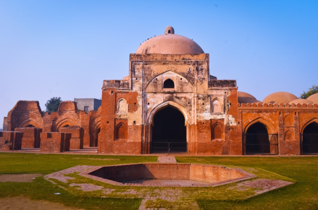 Landschaps-foto's van-Kabuli-bagh-masjid-voorzijde-met-een-kant-beschadigd-Tombe-en-wand-blauw-sky-en-groen-gras-Panipat-India.jpg
